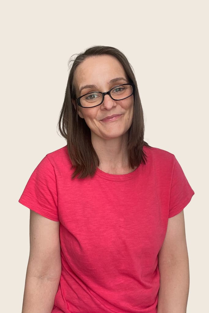Rachel Jackson Marketing Tech Specialist. A headshot of Rachel Jackson, with long straight brown hair and black glasses wearing a red t shirt.